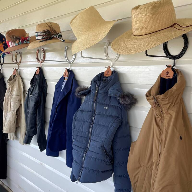 row of hats and coats on handmade horseshoe racks