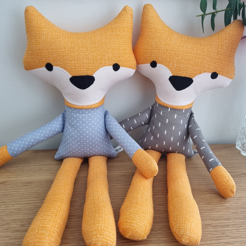 two children's fabric soft toy foxes