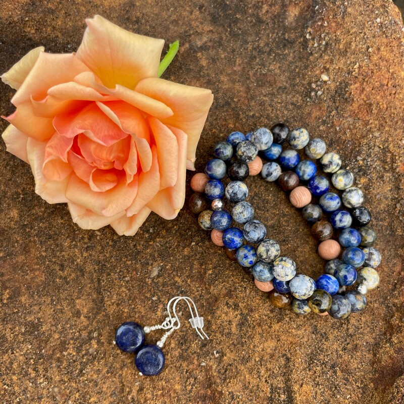 blue, pink & grey bead bracelet beside an orange coloured rose