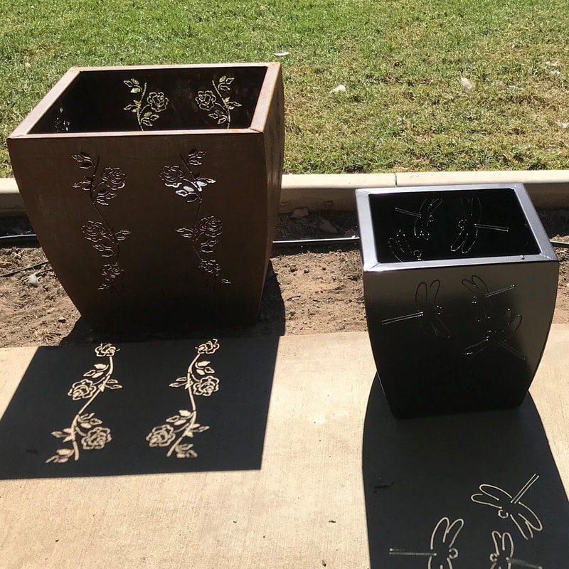 metal plant pots with laser cut flower designs cut into the sides