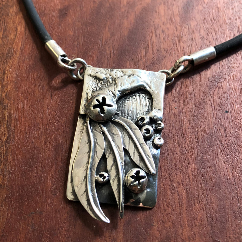 handmade silver pendant featuring gum leaves & flowers