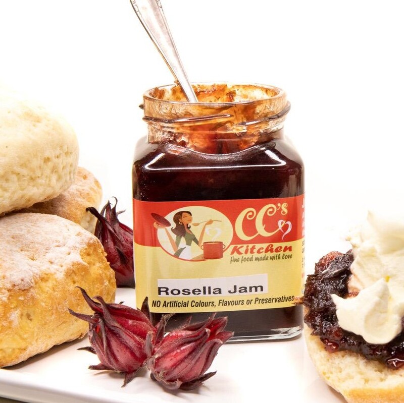 jar of rosella jam with fresh rosellas, scones and cream