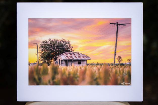 image of an old farm house in a paddock at sunset