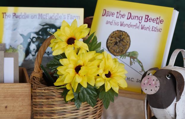 basket of flowers with a children's book about dung beetles